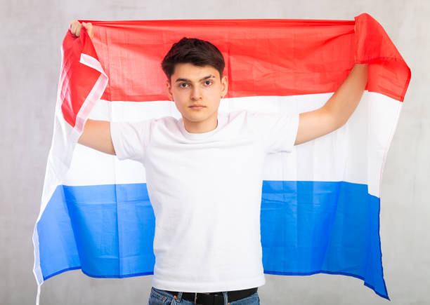 istock Focused young guy holding Netherlands flag 1489259819