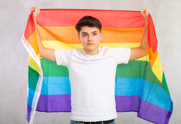 istock Focused young guy holding LGBT flag 1489259850