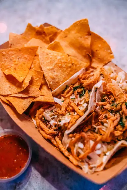 Close-Up Shot of Delicious Fish Street Tacos and Corn Tortilla Chips from Local Business Taco Shop in San Diego under Vibrant-Colored Lighting
