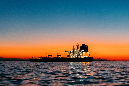 Silhouette of a Large Empty Cargo Ship at Sunset on the Pacific Ocean at Huntington Beach, California near Los Angeles