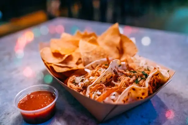Delicious Fish Street Tacos and Corn Tortilla Chips from Local Business Taco Shop in San Diego under Vibrant-Colored Lighting