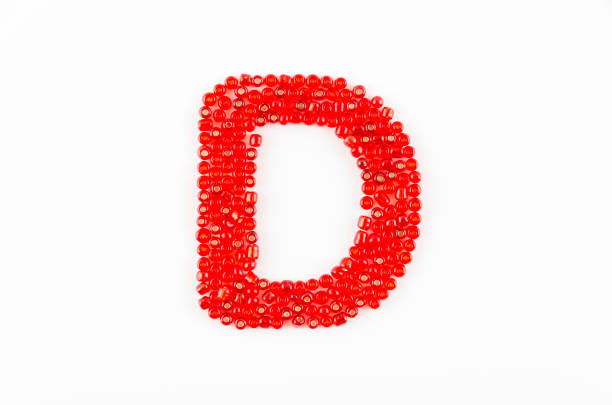 Alphabet of red beads on white background D