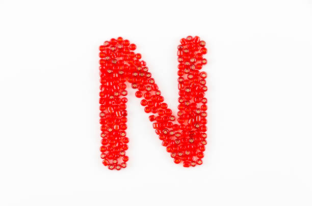 Alphabet of red beads on white background N