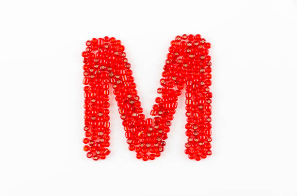 Alphabet of red beads on white background M