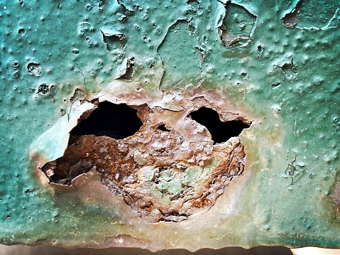 Rust Hole in Painted Metal