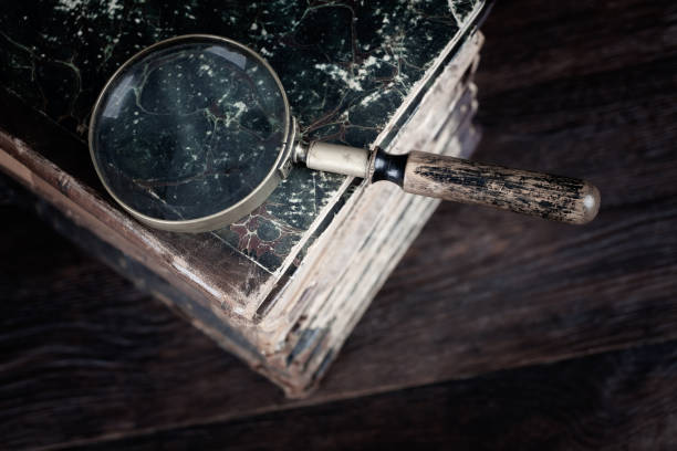 istock Old vintage magnifying glass with books on table 1489274985
