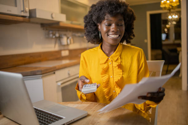 istock Young woman using calculator while going through bills and home finances 1489277770