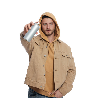 Handsome man holding can of spray paint on white background