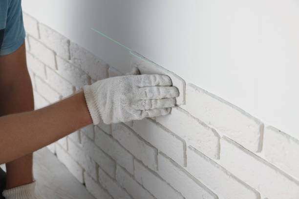 istock Worker installing decorative wall tiles in room, closeup 1489280029