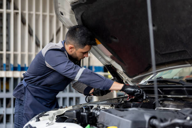 mechanic checking the battery on a car - electric motor fotos imagens e fotografias de stock