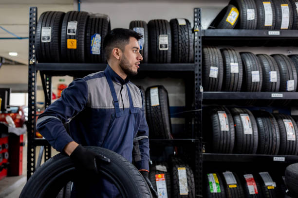 istock Mechanic changing a tire and holding the replacement at a repair garage 1489285809