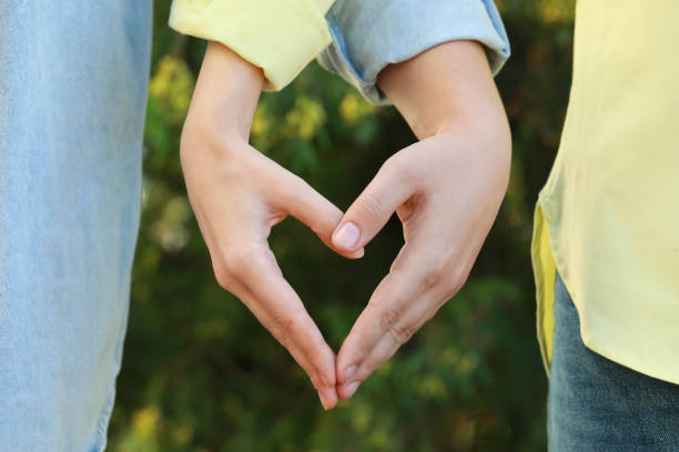 istock Couple making heart with hands outdoors on sunny day, closeup 1489287474