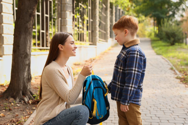 istock Young mom giving school backpack to her son outdoors 1489287842