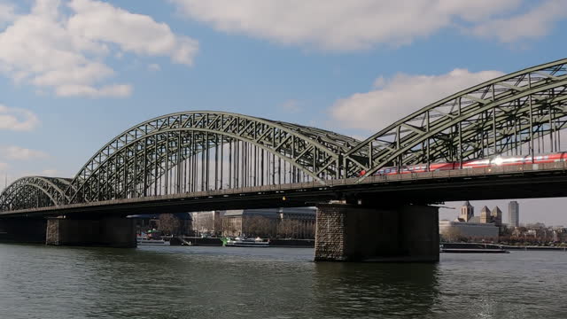 Panoramic view of Cologne Cathedral and trains passing on Hohenzollern Bridge in Cologne, Germany