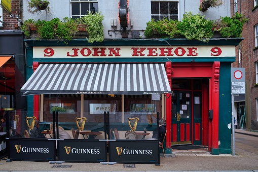 Dublin - March 2023:  Colorful Dublin pub with outdoor seating under a striped awning