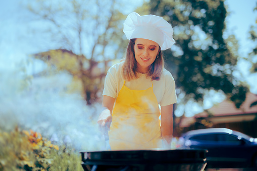 Cheerful home cook making a meal outside barbecue style