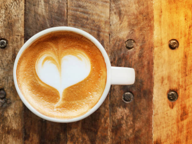 istock Heart-shaped latte art coffee in a ceramic coffee mug placed on a wooden table with copy space 1489314411