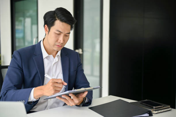 istock Smart Asian businessman focuses on rechecking business documents 1489316752