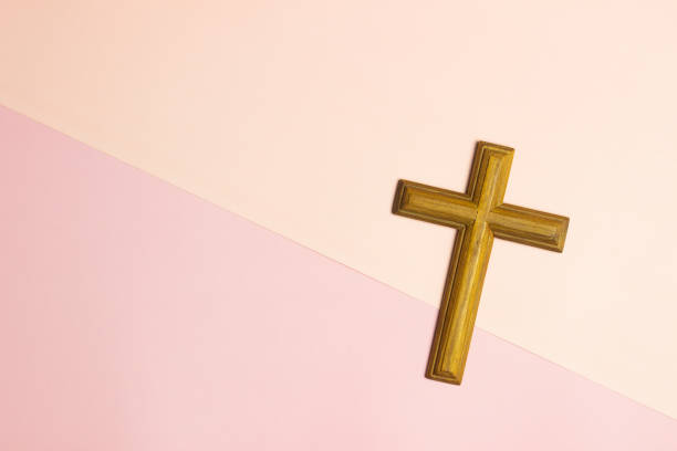 istock A wooden cross over pink background with copy space. 1489316964