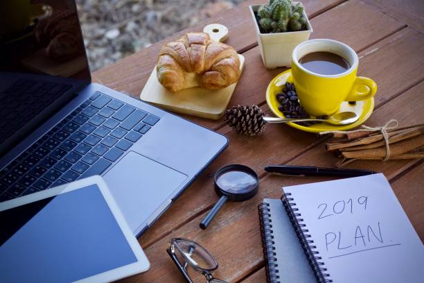 Work desk with a cup of hot coffee in the morning on a nice day.