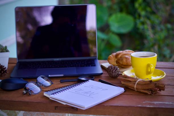 Work desk with a cup of hot coffee in the morning on a nice day.