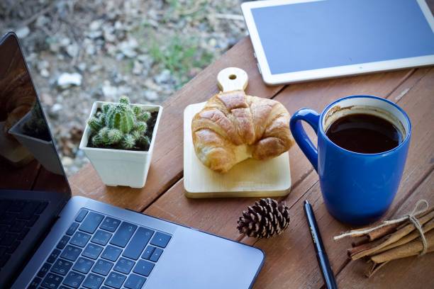 Work desk with a cup of hot coffee in the morning on a nice day.