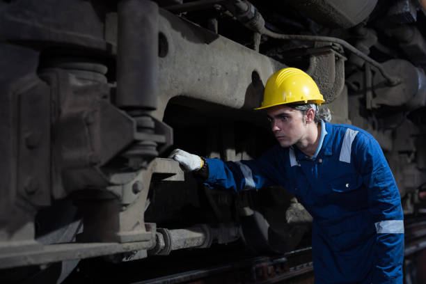 istock Male engineer worker maintenance locomotive engine. Technician inspecting quality parts of locomotive engine in locomotive garage. Male railway engineer repair engine in garage 1489320075