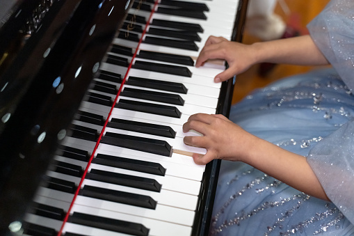 Hands of a child playing the piano