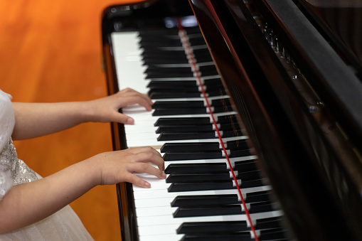 Hands of a child playing the piano