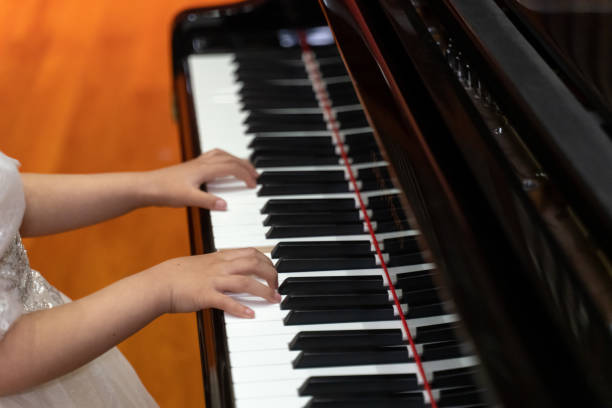 Hands of a child playing the piano Hands of a child playing the piano girl playing piano stock pictures, royalty-free photos & images