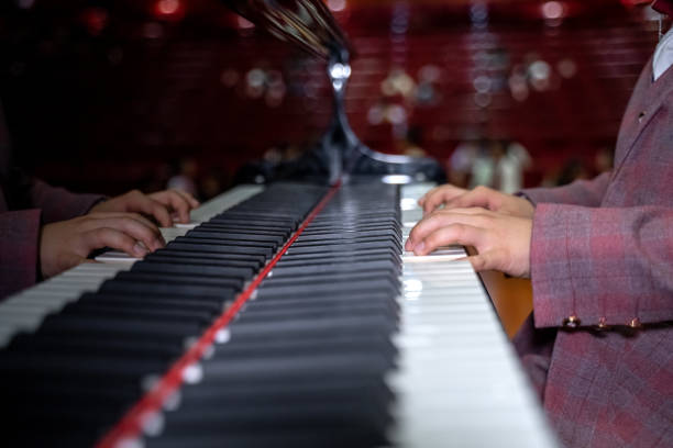 A pair of boy's hands are playing the piano