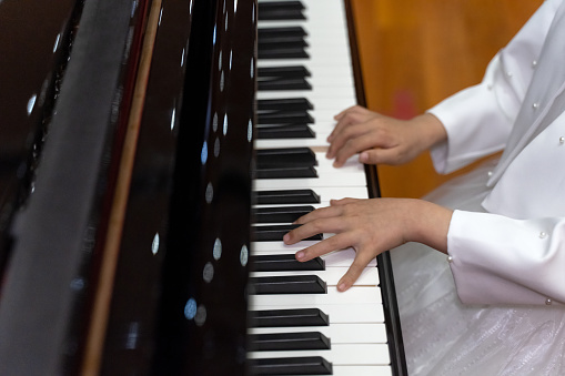 Close up of the hands of a child practicing the piano
