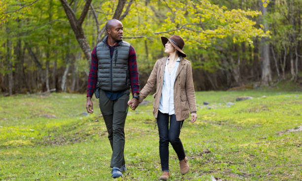 istock A multi race heterosexual couple walking hand in hand in nature 1489330285