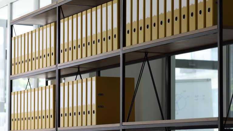 Lot of yellow folders for documents are placed on bookshelf in archive timelapse hyperlapse