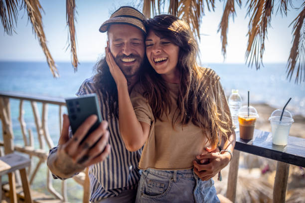 istock Cheerful couple taking selfie in a beach bar 1489335080