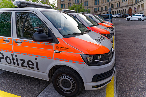 Side view of parked police vans in a row type VW Transporter at main police station of city police at City of Zürich on a spring evening. Photo taken May 6th, 2023, Zurich, Switzerland.