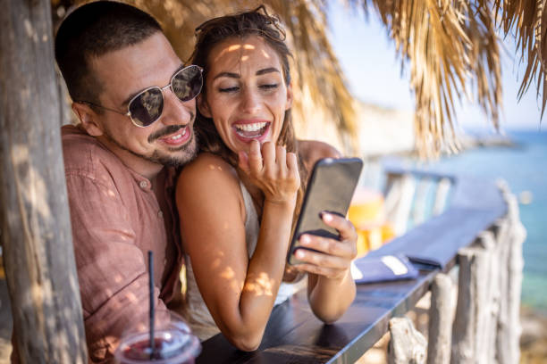 istock Cheerful couple taking selfie in a beach bar 1489339777