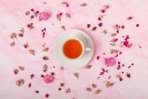 istock Cup of tea on pink background with flowers. Top view. 1489343651