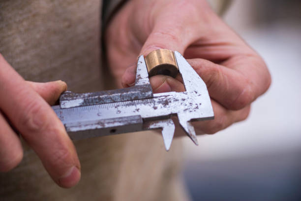 istock metal shtangel  bar circulates Auto mechanical carefully measures the desired part The worker is measuring to inner diameter of flange with vernier caliper gauge Pipe Men's Hands Holding 1489347313