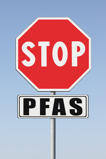 Stop dangerous PFAS per-and polyfluoroalkyl substances used in products and materials due to their enhanced water-resistant properties - Concept with stop road sign