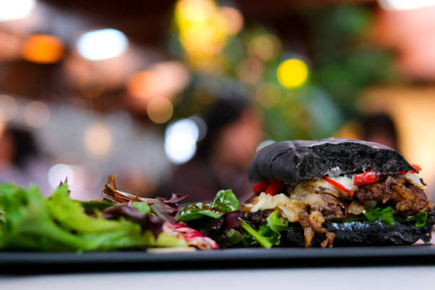 istock bulgogi, spicy bulgogi, house-made, squid inc bread, beef black bread bun with cuttlefish ink sandwich hamburger restaurant serving with salad on a black plate near the window delicious appetizing 1489347663