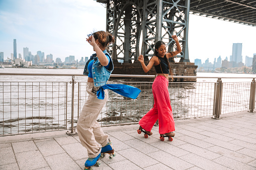 Two friends dancing on roller skates in Williamsburg, Brooklyn, New York.