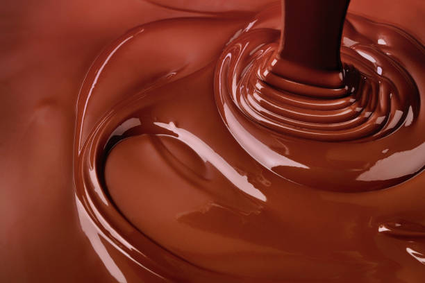 istock pouring chocolate background. cocoa syrup flowing forming ripples 1489353793
