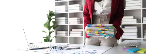 istock woman hands working in stacks of paper files document achieves on folders papers. copy space 1489353916