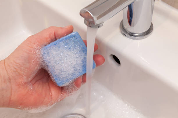 istock Hand holding soap under tap water 1489355479