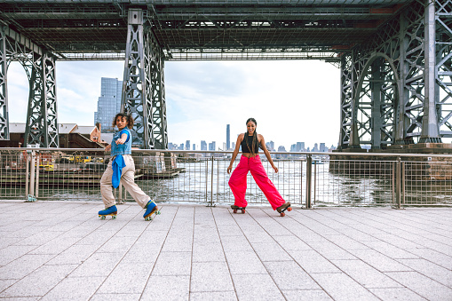 Two friends dancing on roller skates in Williamsburg, Brooklyn, New York.