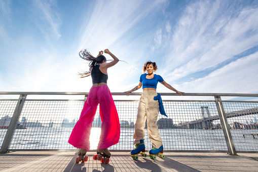 Two women friends on roller skates in Williamsburg, Brooklyn, New York.