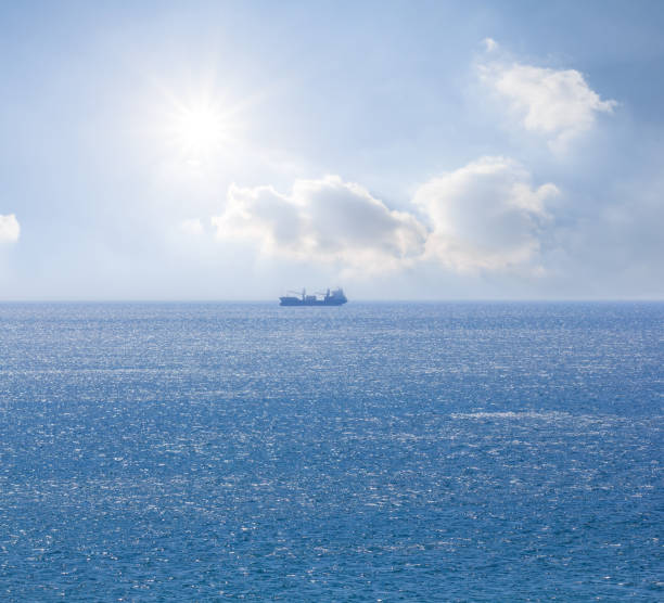 istock alone cargo ship among blue sea under sparkle sun, sea transportation background 1489358754