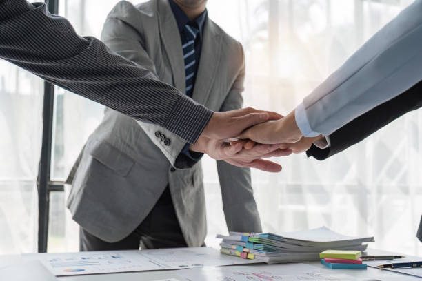 istock Analyst business team putting hand together after successfully analyzed financial dashboard papers for business strategy and marketing. Teamwork and unity in office with stack hands 1489360530