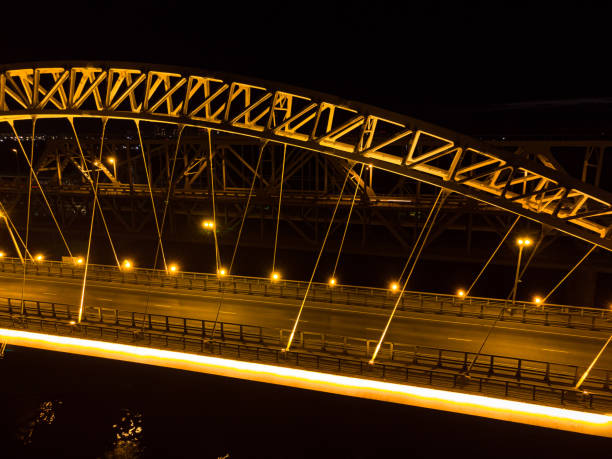 jasne światła, mosty z łukami, nocne miasto. most drogowy przez rzekę, zaczerpnięty z drona. - traffic city urban scene nature zdjęcia i obrazy z banku zdjęć